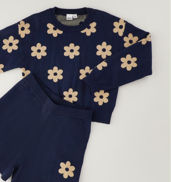 Detail van het beige bloemenmotief op de donkerblauwe gebreide iDO set